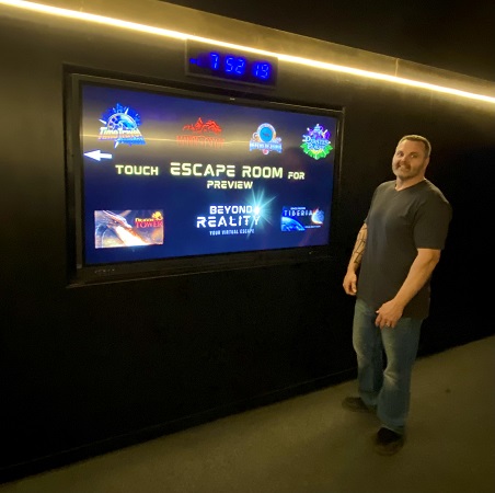 Beyond Reality owner/operator Darcy Willey with touch screen display for virtual reality games